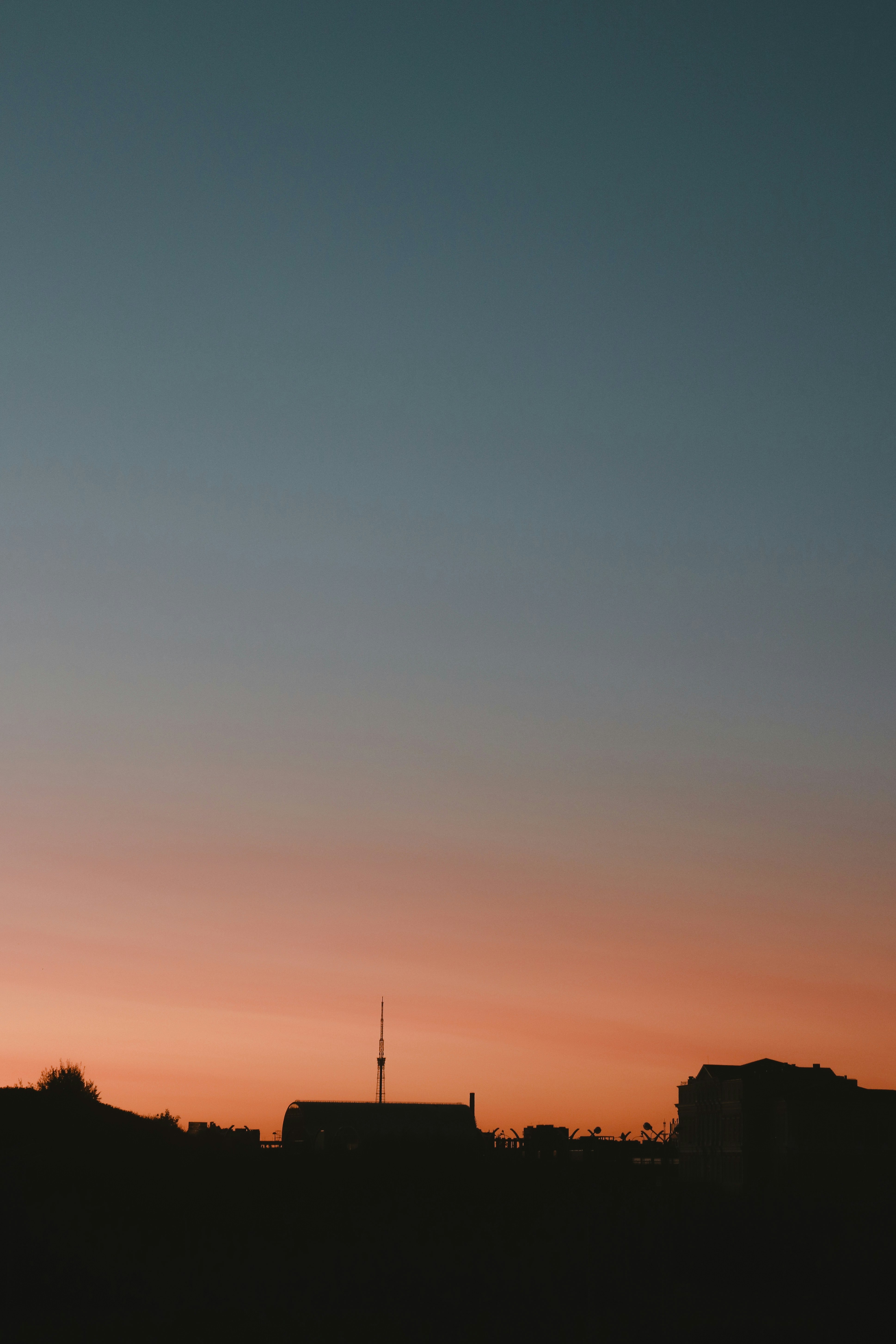 silhouette of person standing on hill during sunset